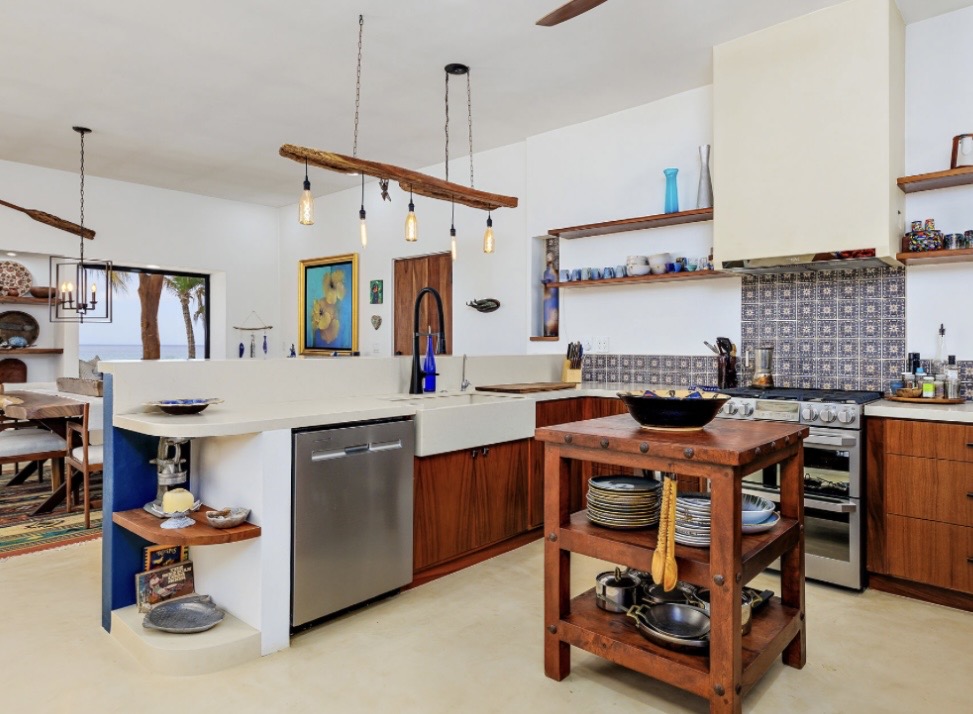 Full kitchen with handmade tile backsplash, wood cabinetry, and hanging Edison lights