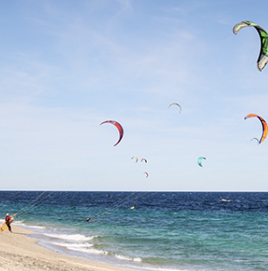Kitesurfers on the Sea of Cortez with colorful kites filling the sky